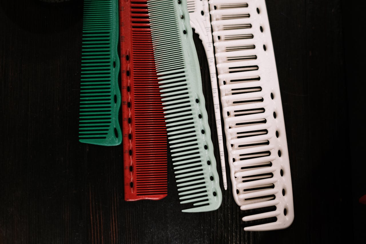 A set of colorful plastic combs arranged on a dark background.
